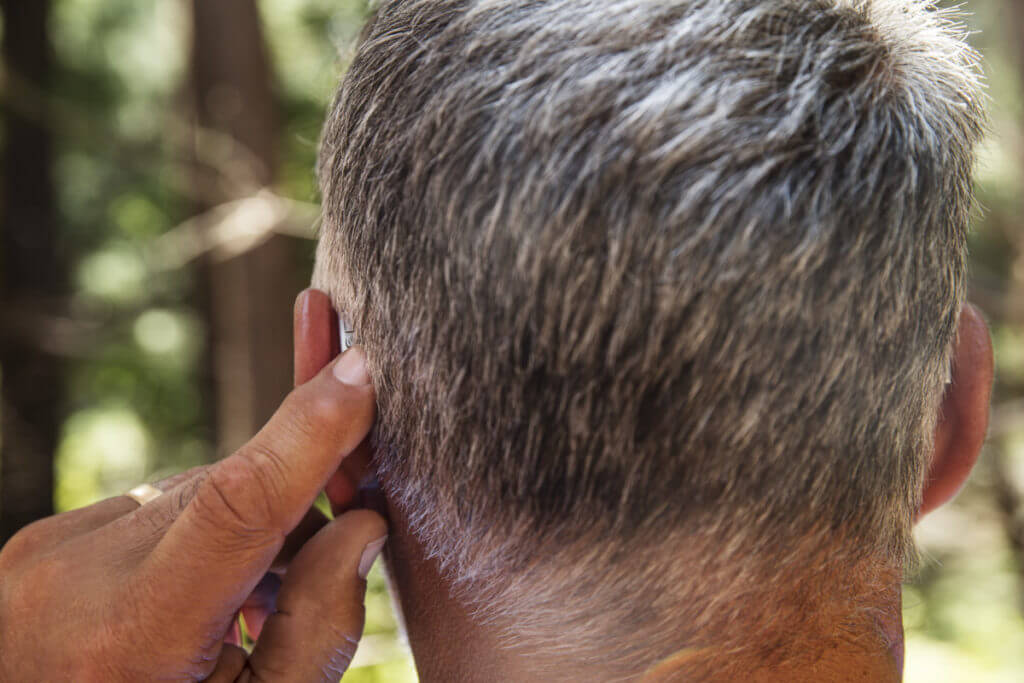 man turning on hearing aid