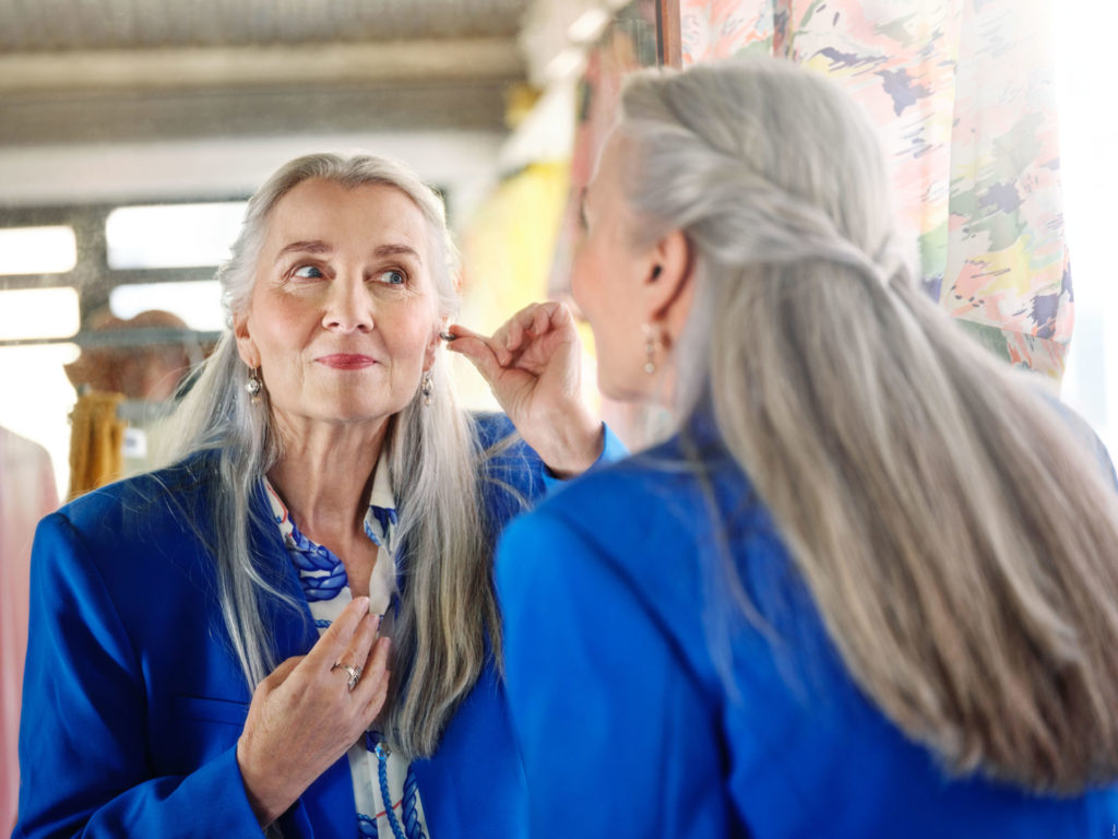 woman putting in hearing aids