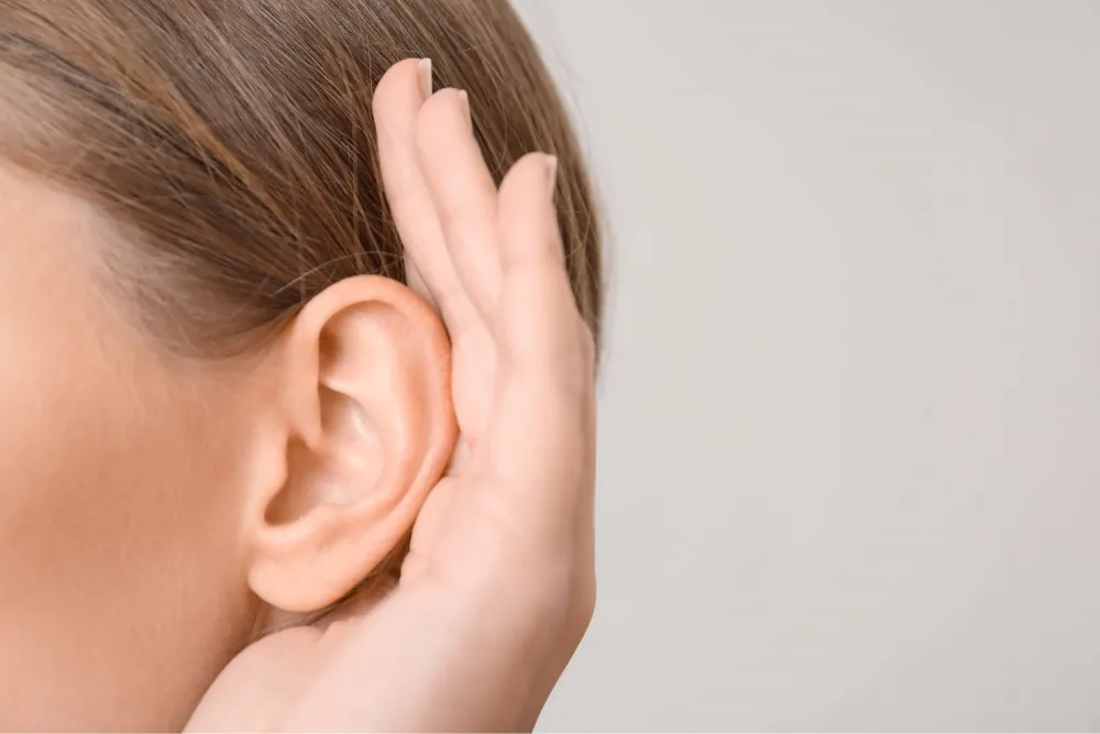 http://Close%20up%20profile%20of%20a%20woman%20cupping%20her%20ear.