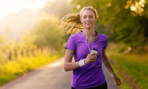 woman jogging wearing custom earphones.